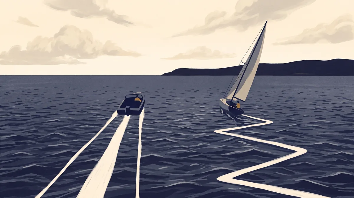 A speedboat and a sailboat on open water, seen from behind, both heading away toward a distant headland. The speedboat trails a straight white wake. The sailboat, heeled on a tack, trails a sharp zigzag track across the same water